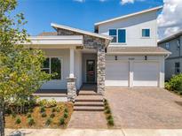 Two-story house with stone accents and a two-car garage at 13187 Mcmillan Dr, Orlando, FL 32827