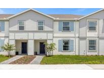 Two-story townhome with light-colored siding and a landscaped yard at 4306 Lana Ave, Davenport, FL 33897