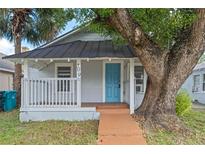 Charming bungalow style home with a blue door and a large tree at 709 Jernigan Ave, Orlando, FL 32805