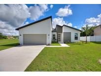 Modern, single-story home with a two-car garage and well-manicured lawn at 1877 Snapper Dr, Kissimmee, FL 34759