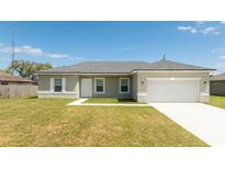 Newly constructed one-story home with a two-car garage and a neatly landscaped lawn at 16846 Sw 47Th Avenue Rd # 06, Ocala, FL 34473