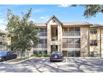 Two-story condo building with balconies, screened porches, and ample parking at 623 Dory Ln # 308, Altamonte Springs, FL 32714