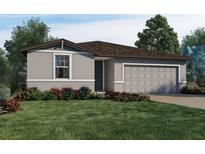 One-story home with gray exterior, two-car garage, and landscaped front yard at 2458 Leeds St, Haines City, FL 33844