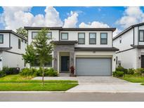 Modern two-story home with gray siding and two-car garage at 5937 High Seas Dr, Orlando, FL 32821