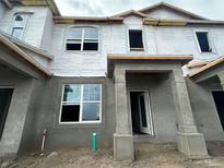 New construction home with gray siding and a covered entryway at 1380 Lumpini St, Saint Cloud, FL 34771