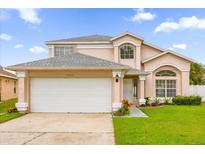 Two-story house with a white garage door and landscaped lawn at 14646 Brightwell Ct, Orlando, FL 32824