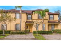 Two story tan home with brown roof and landscaping at 121 Palermo St, Davenport, FL 33897