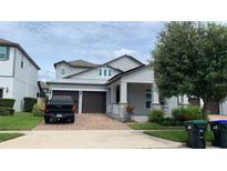 Two story home with gray siding, brown garage doors, and landscaped yard at 14739 Glade Hill Park Way, Winter Garden, FL 34787