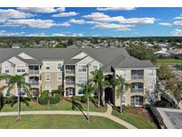 Exterior of a large apartment building with palm trees and landscaping at 8100 Princess Palm Ln # 305, Kissimmee, FL 34747