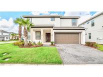Two-story house with brown garage door and palm trees in front at 2610 Calistoga Ave, Kissimmee, FL 34741