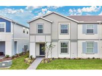 Two-story townhome with gray siding, shutters, and a landscaped front yard at 3894 Lana Ave, Davenport, FL 33897