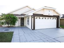 Front view of a single-story house with a two-car garage and landscaped yard at 6632 Meritmoor, Orlando, FL 32818