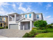 Two-story home with a gray exterior, gray garage door, and landscaping at 7736 Graben St, Kissimmee, FL 34747