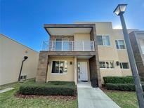 Modern two-story home with balcony, neutral colors, and landscaping at 3131 Brasilia Ave, Kissimmee, FL 34747