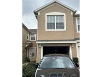 Two story tan house with a garage and landscaping at 6462 Cantua Ln # 105, Orlando, FL 32835