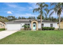 House exterior featuring a garage and landscaping at 1053 E Hancock Dr, Deltona, FL 32725