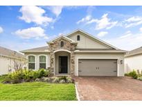 Exterior of a charming ranch-style home with stone accents and a two-car garage at 1554 Outback W Rd, Saint Cloud, FL 34771