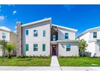 Two-story modern home with gray siding and red door at 2734 Oxymoron Way, Kissimmee, FL 34746