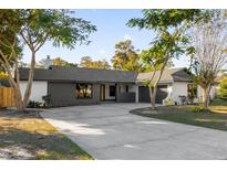 Modern home exterior with gray and white accents, a long driveway, and landscaping at 4030 Bibb Ln, Orlando, FL 32817