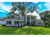 Two-story house with gray siding, dark windows, and a lush green lawn at 6893 Hidden Glade Pl, Sanford, FL 32771