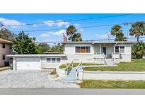 Charming bungalow-style home with a white garage and landscaped yard at 131 Mitchell Pl, Daytona Beach, FL 32118