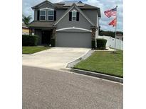 Two story house with gray siding, solar panels, and double car garage at 1952 Dunn Cove Dr, Apopka, FL 32703