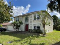 Two-story house with attached garage and landscaping at 3001 Mandolin Dr, Kissimmee, FL 34744