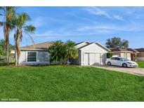 Single story house with a green lawn and driveway at 627 Mesilla Dr, Kissimmee, FL 34758