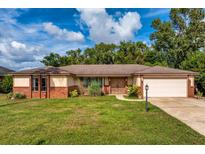 Brick ranch home with a two-car garage and well-maintained lawn at 758 Tamerlane St, Deltona, FL 32725