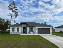 New construction home with gray garage door and modern design at 16153 Sw 24Th Court Rd, Ocala, FL 34473