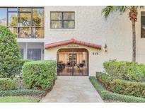 Inviting building entrance with gated access, landscaping, and a walkway at 535 N Interlachen Ave # 305, Winter Park, FL 32789