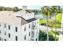 White building with a balcony, lake view, and palm trees at 770 Siena Palm Dr # 305, Celebration, FL 34747