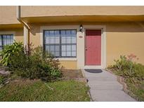 Inviting condo entrance with red door, landscaping, and walkway at 3390 Cedar Spring Pl # 163, Winter Park, FL 32792