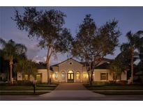 Luxury home exterior at twilight, showcasing architectural details and landscape lighting at 8681 Crested Eagle Pl, Sanford, FL 32771