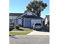 Gray house with a two-car garage and a landscaped lawn at 2314 Carriage Run Rd, Kissimmee, FL 34741