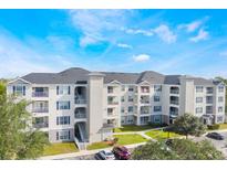 Modern apartment building with ample parking and lush landscaping at 3177 Feltrim Pl # 104, Kissimmee, FL 34747
