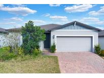Single-story home with gray siding, brick driveway, and landscaping at 416 Mckenna Dr, Winter Haven, FL 33881