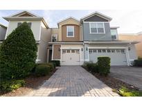 Two-story townhome with two-car garage and landscaped walkway at 1166 Presidential Ln, Apopka, FL 32703