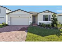 Single-story home with gray siding, brick accents, and a two-car garage at 4706 Jasmine Cir, Leesburg, FL 34748