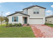 Two-story house with gray siding, teal shutters, and a brick driveway at 4710 Jasmine Ct, Leesburg, FL 34748