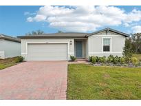 One-story home with gray siding, a two-car garage, and landscaped yard at 4736 Jasmine Cir, Leesburg, FL 34748