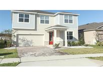 Two-story house with gray siding, red door, and a paved driveway at 7916 Waterfield Ave, Orlando, FL 32832