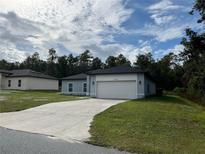 Newly constructed home with a two-car garage and well-maintained lawn at 13739 Sw 43Rd Cir, Ocala, FL 34473