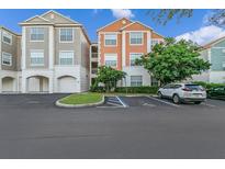 Two-story condo building with ample parking and landscaping at 12843 Madison Pointe Cir # 107, Orlando, FL 32821