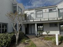 Exterior view of condo building with walkway and landscaping at 2520 Woodgate Blvd # 202, Orlando, FL 32822