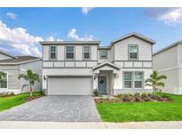 Two-story home with gray siding and gray paved driveway at 3032 Mahalo Dr, Davenport, FL 33897