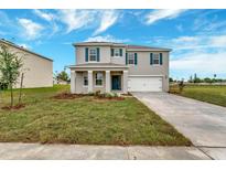 Two-story house with gray siding, blue shutters, and a white garage door at 1209 Limbali St, Mount Dora, FL 32757