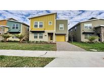 Modern two-story home with yellow and gray exterior at 2736 Bookmark Dr, Kissimmee, FL 34746