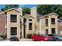Tan apartment building with balconies and ample parking at 4400 Thornbriar Ln # 201, Orlando, FL 32822
