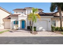 Charming two-story home with a blue door, attached garage, and landscaped front yard at 148 Brunello Dr, Davenport, FL 33897